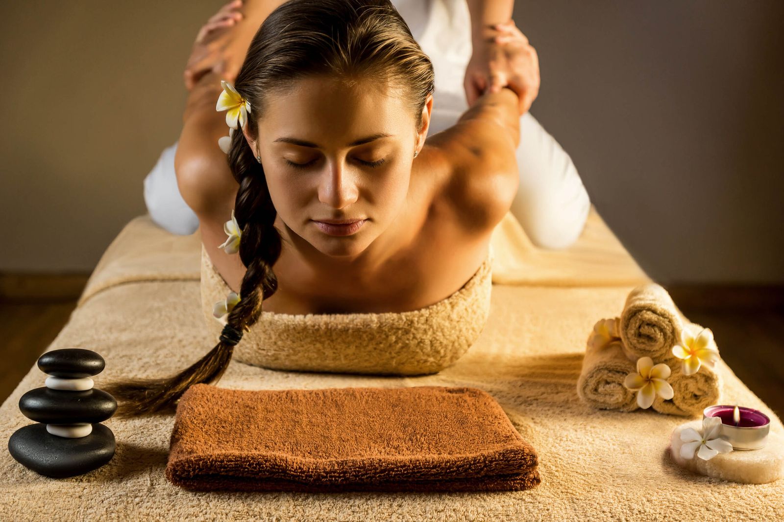Ruhige Thai-Massage-Behandlung mit Frangipani-Blüten und warmem Licht