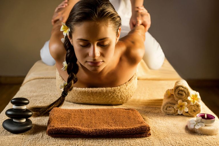 Thai-Massage: Dehnung im Liegen auf der Massagematte